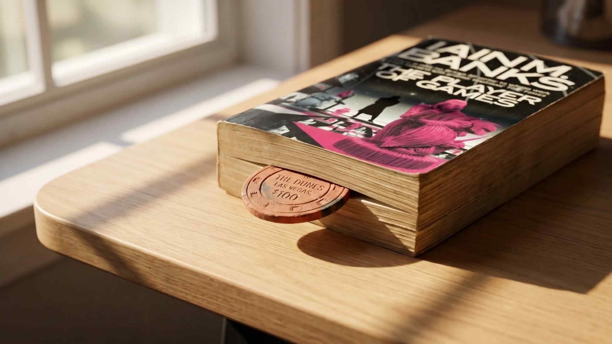 A copy of the novel The Player of Games with a casino chip wedged between the pages.